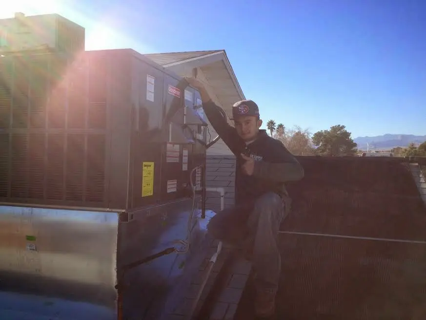HVAC technician performing AC Tune-Up on a rooftop unit in Michigan City